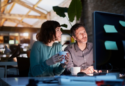 Lenvi - new consumer report - Man and woman in an office setting, focused on a computer, representing consumer lending analysis.