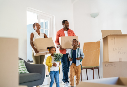 People moving boxes into a new home with children and household belongings